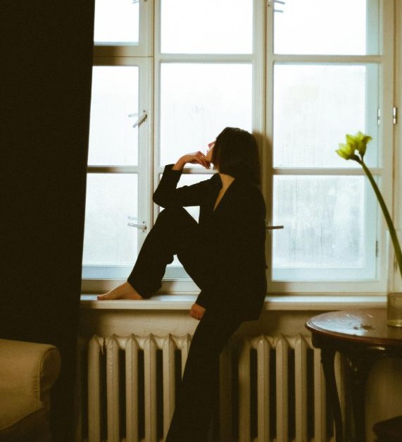 woman looking out window contemplatively